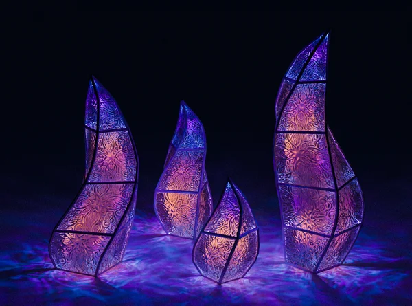 Illuminated spiral tower sculptures glowing violet and blue